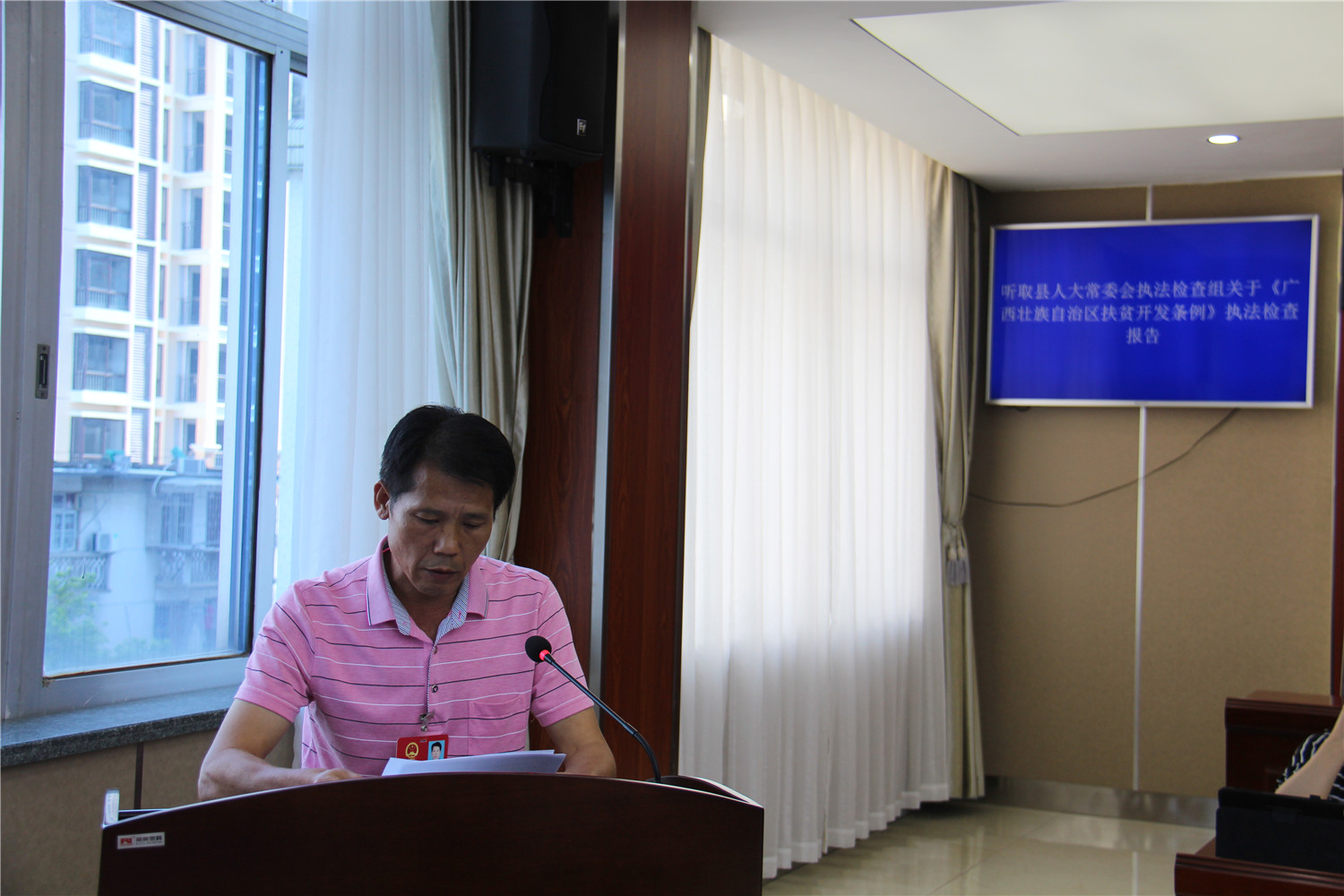 听取县人大常委会执法检查组关于《广西壮族自治区扶贫开发条例》执法检查报告